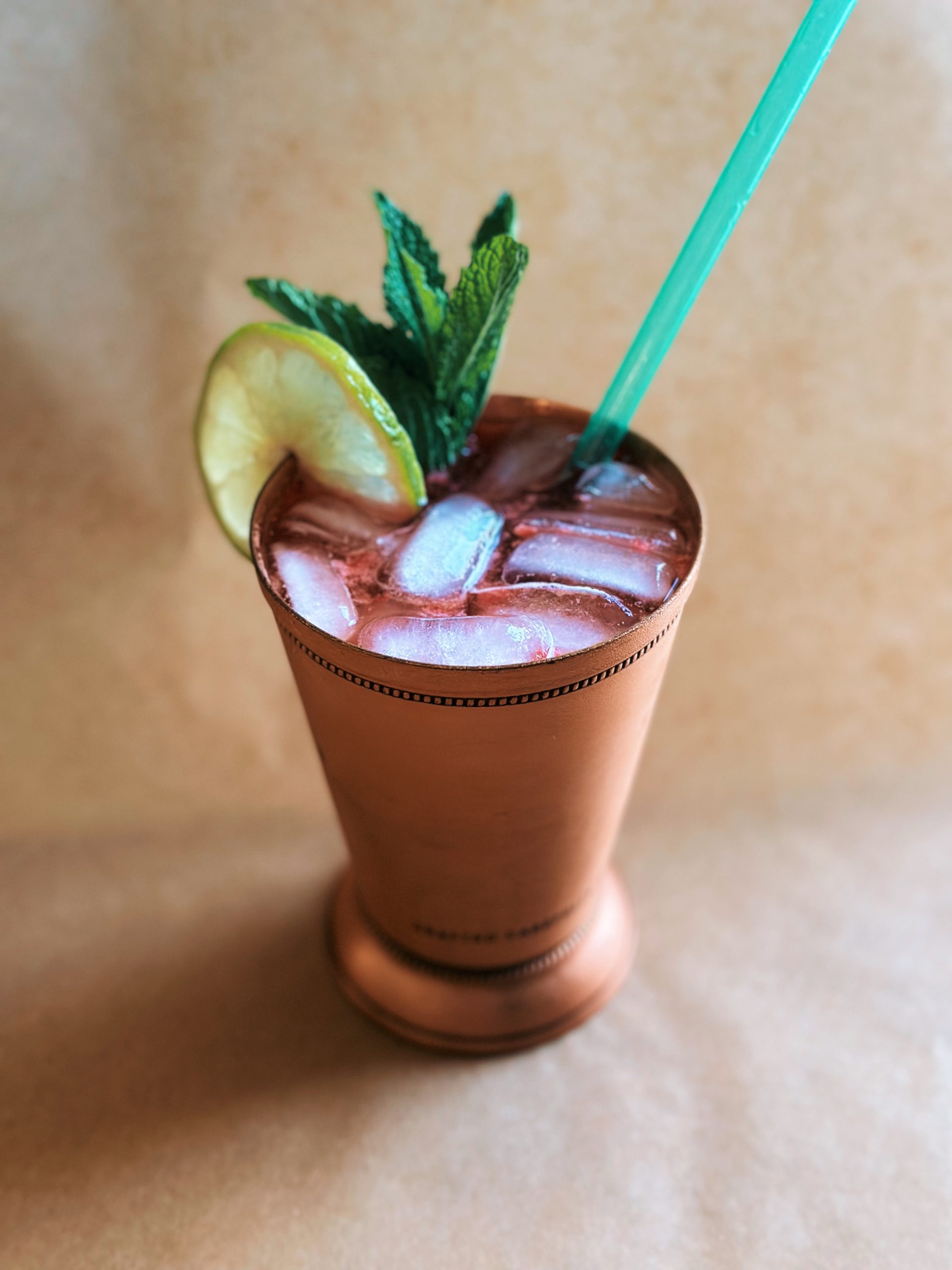 Hannah's Enchantments nonalcoholic cocktail in a cooper mug, garnished with a lime wheel and mint sprig.