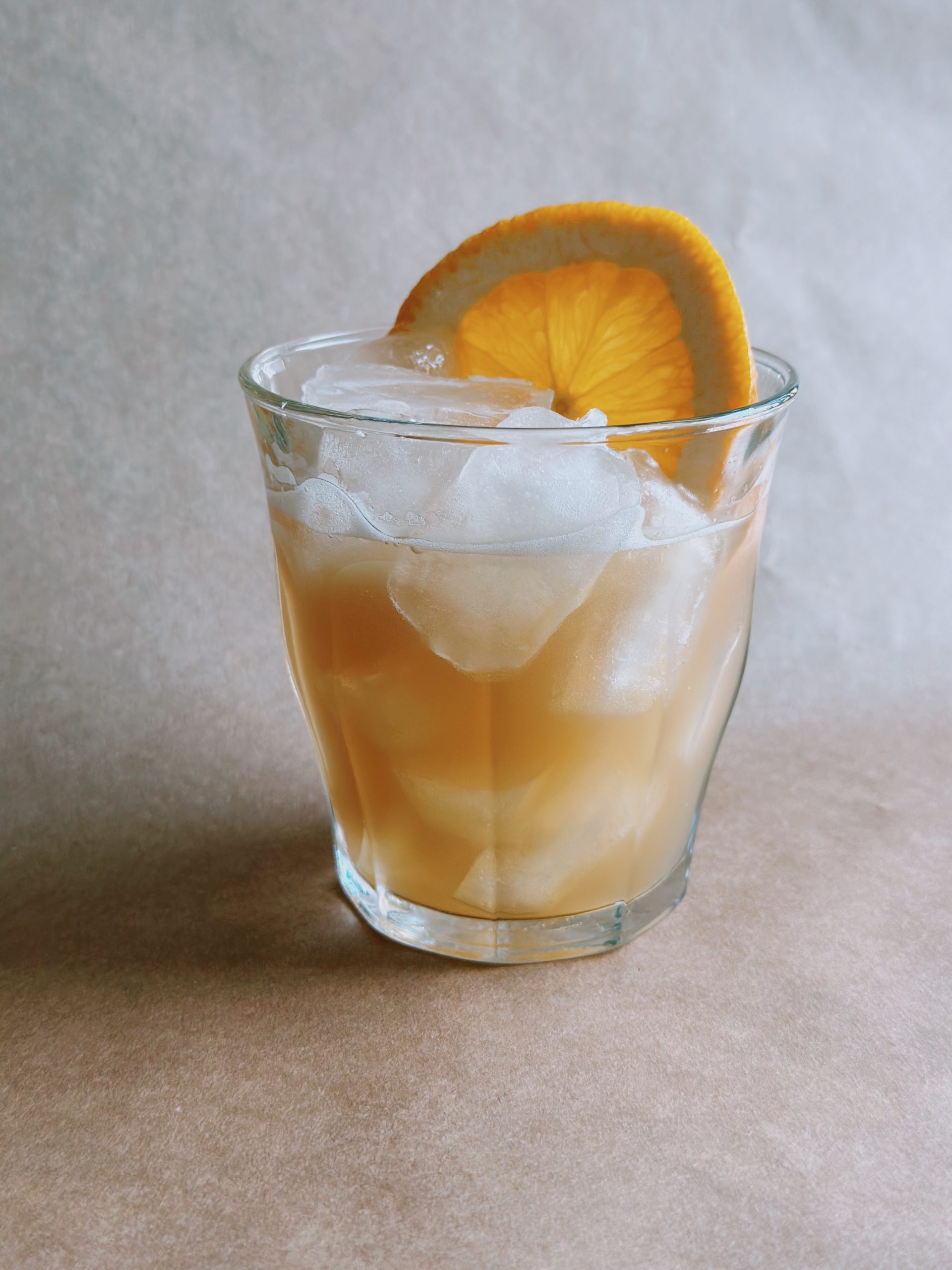 Nonalcoholic Amaretto Sour in a low ball class with ice and slice of orange