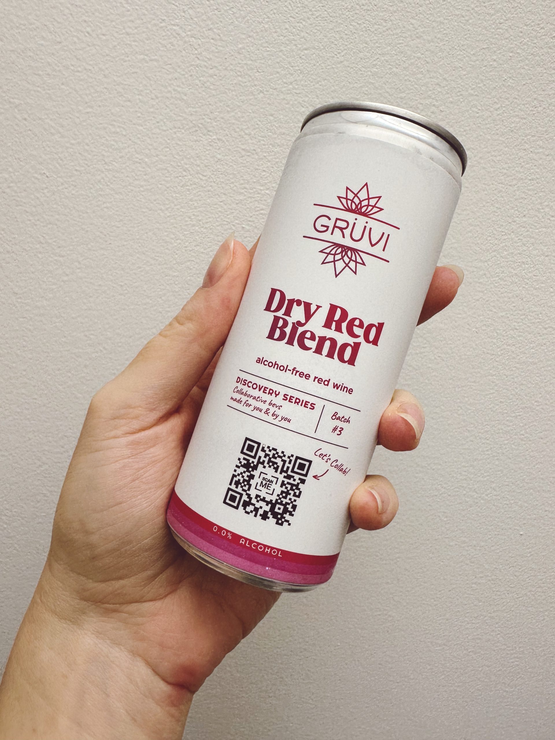 Hand holding a can of Grüvi Alcohol Free Dry Red Blend