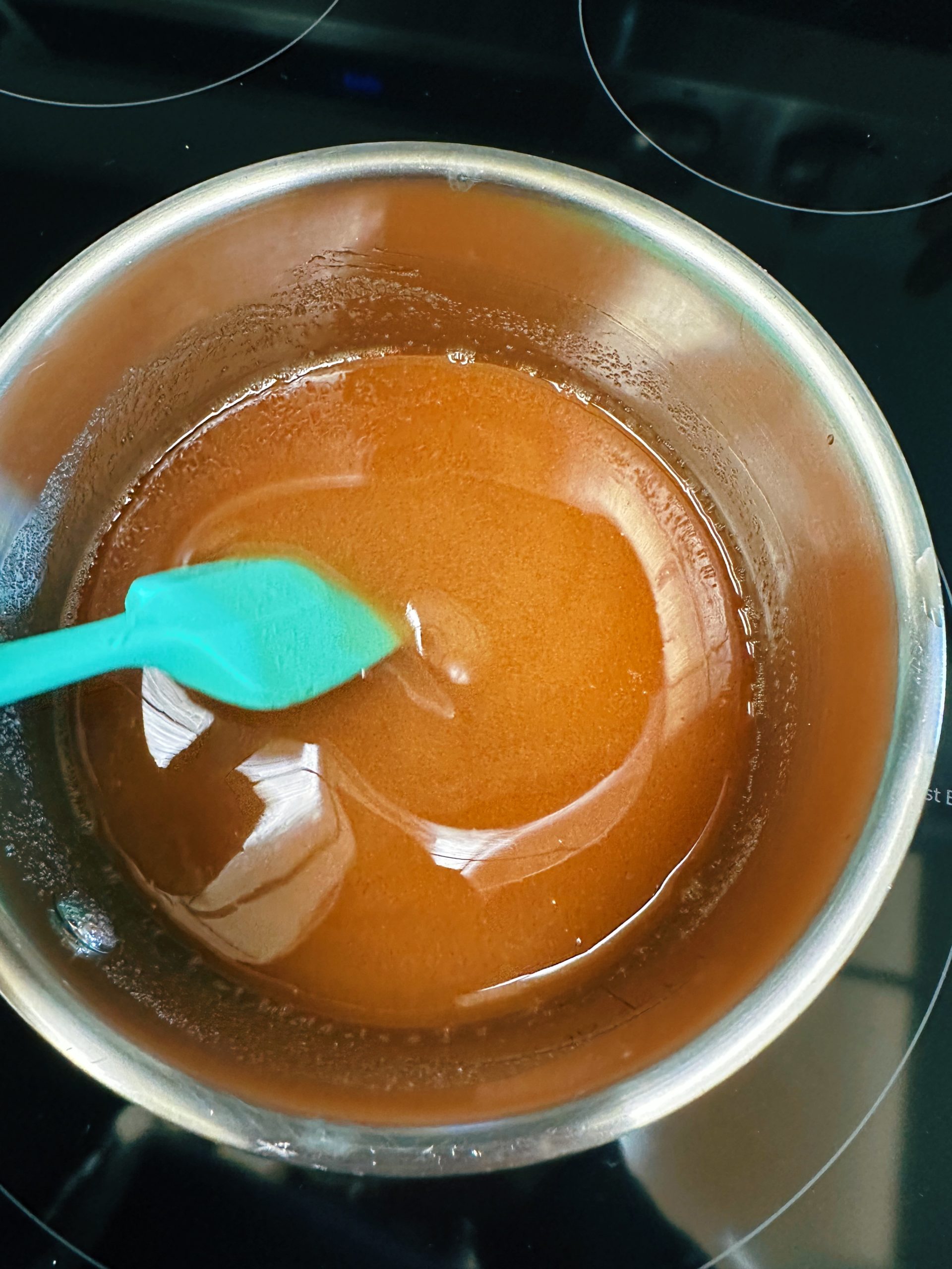 Stirring together sugar and vinegar in a saucepan.