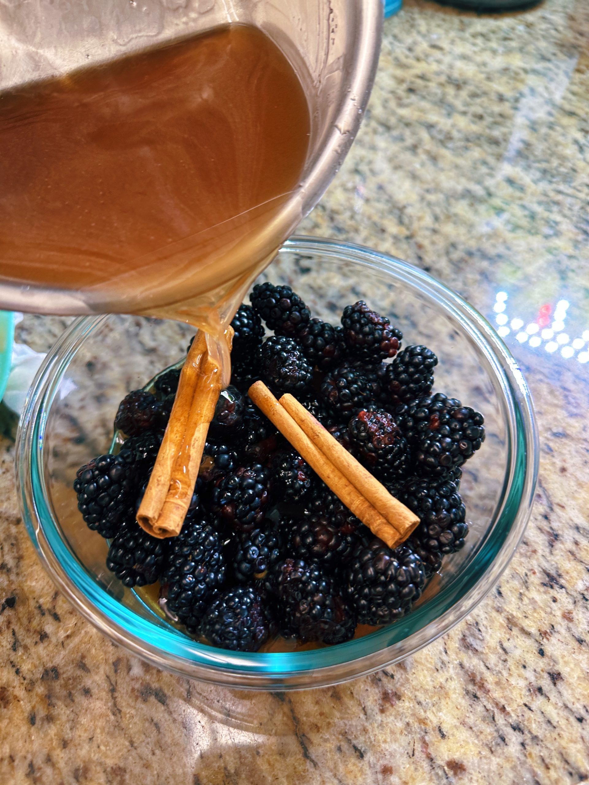 Pouring the hot sugar and vinegar mixture over the blackberries