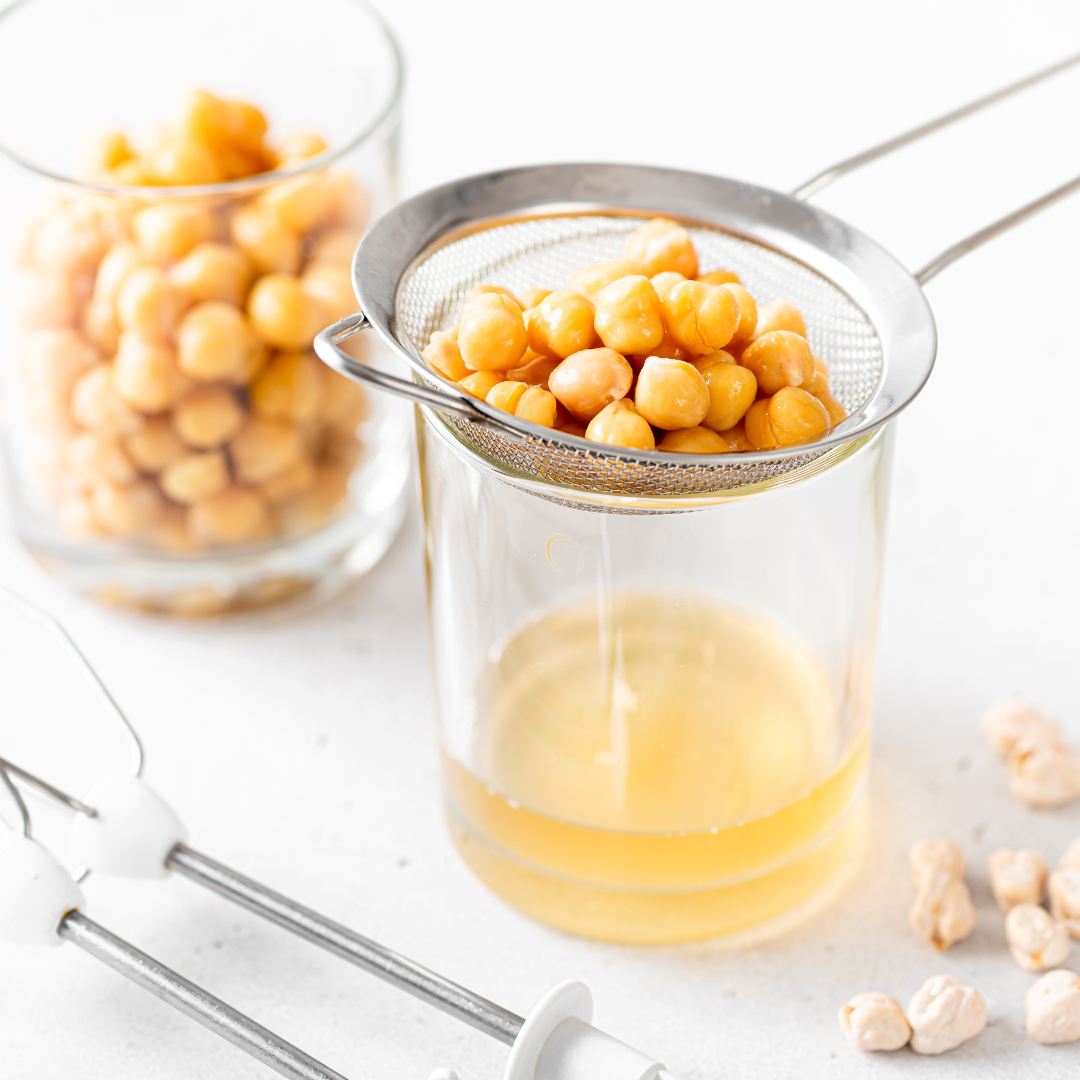 Chickpeas draining through fine mesh sieve to reserve aquafaba juice